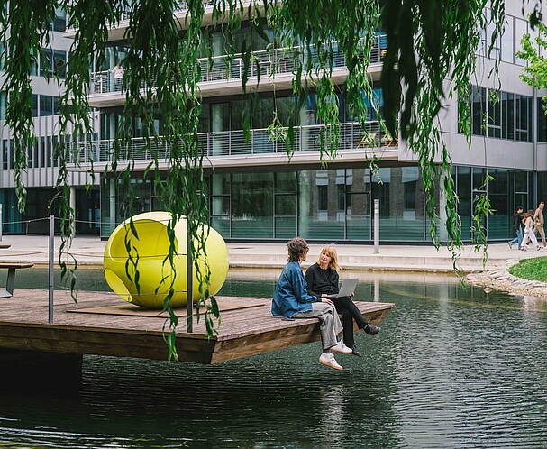 Two women sitting on a pier