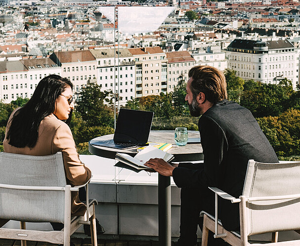 Man and woman on terrace working and overlooking Vienna