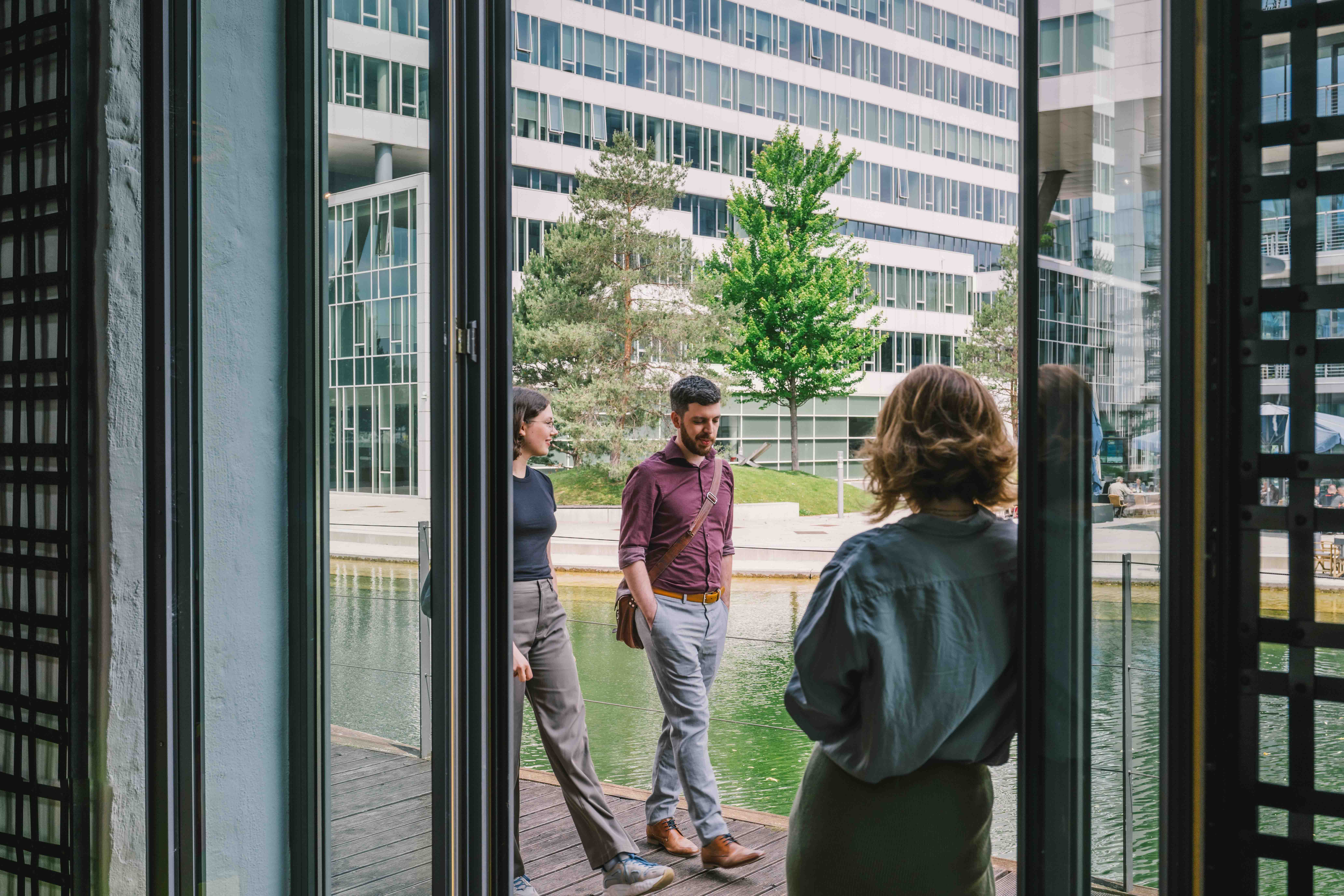Woman standing in door, looking at two people passing buy
