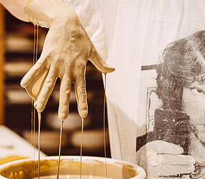 Wet clay runs from the hand