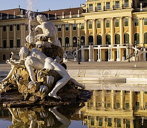The Ehrenhof Fountain with white sculptures in front of Schönbrunn Palace