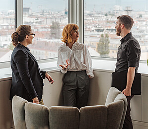 Three people talking while standing