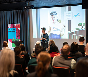 Picture of a speaker with audience in the foreground