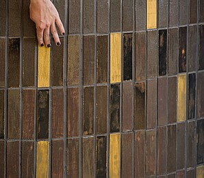 Close up of bar, focus on tiles which have been developed at Biofabrique Vienna hand touches surface