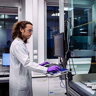 Boehringer Ingelheim Vienna A man in a lab coat working at a computer in a lab