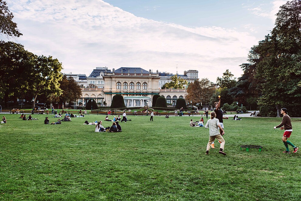 People playing on the grass in the Vienna Stadtpark.