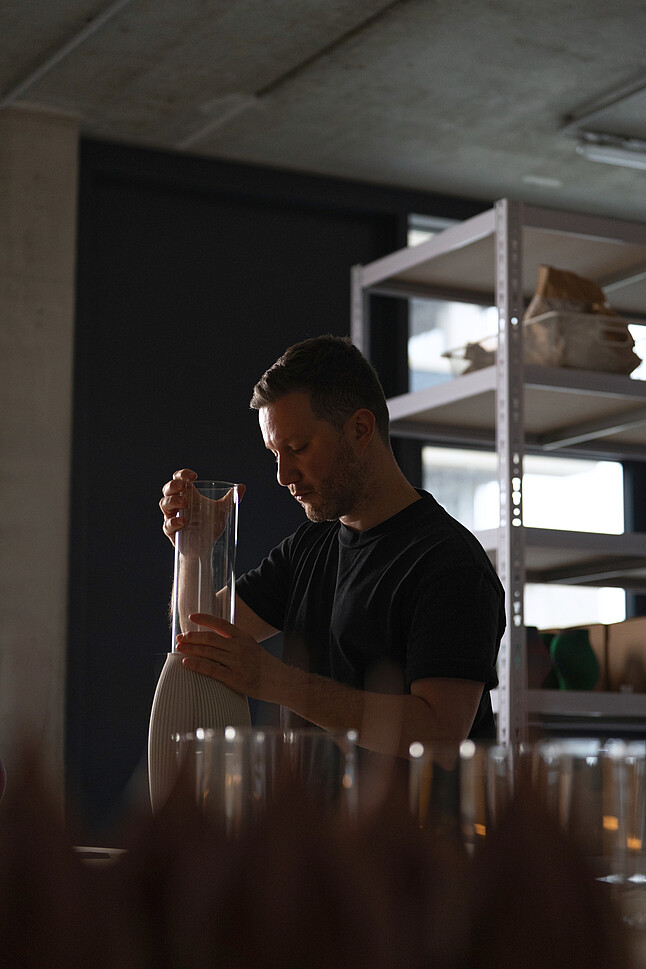 Nicolas Gold von Sheyn packt den Glasbehälter in die Vase
