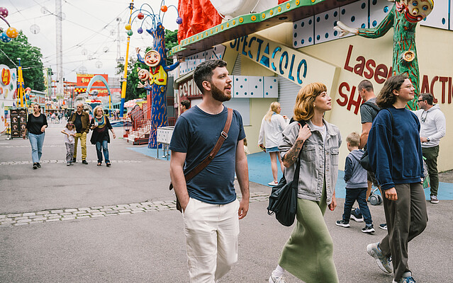 Expats in Prater A man and two women walking through an amusement park