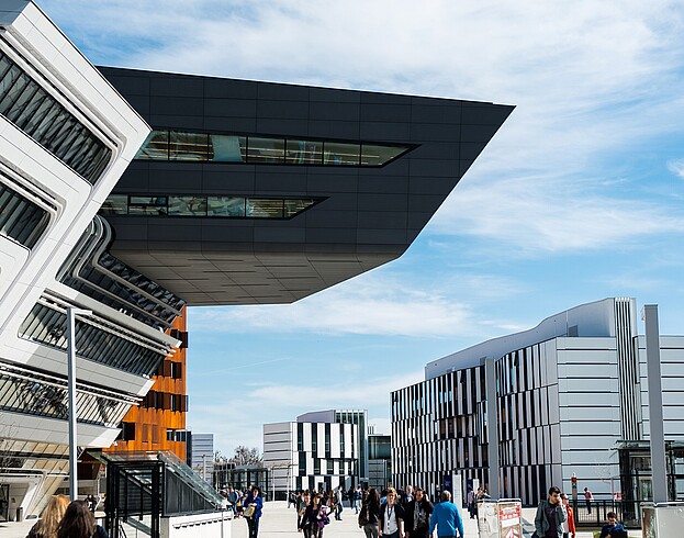 People walking along a street of modern buildings on a sunny day