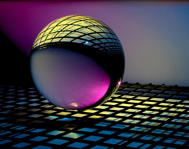 Rendering of a flat grid reflected on the surface of a black sphere.