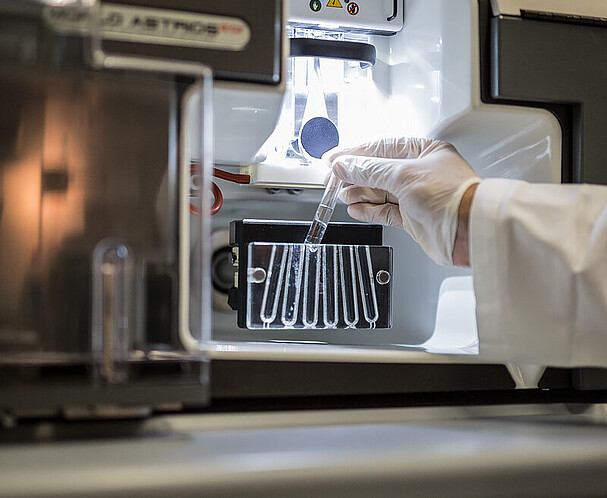 HealthTech hub Vienna A hand putting a vial with clear liquid in it into a medical device