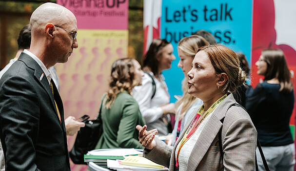 A man and a woman talking at a conference