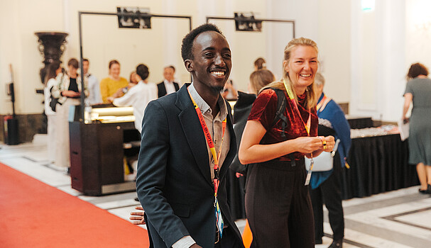A man and a woman laugh as they walk through the lobby of the Impact Days, an event that is part of startup festival ViennaUP.