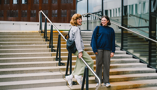 Two women talking and smiling on some steps