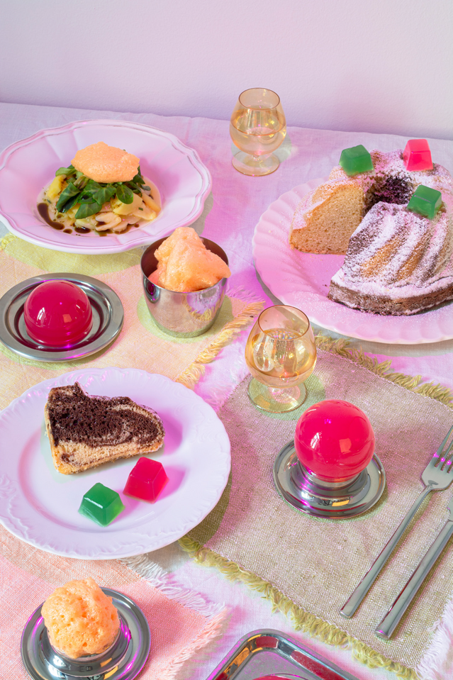 A spread of food and beverages on a pink table