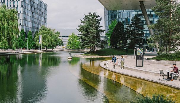 Two women, a dog and a men in front of modern buildings in Vienna