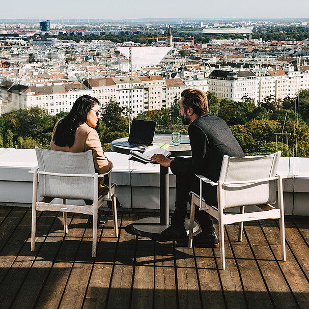 Man and woman on rooftop with view over Vienna