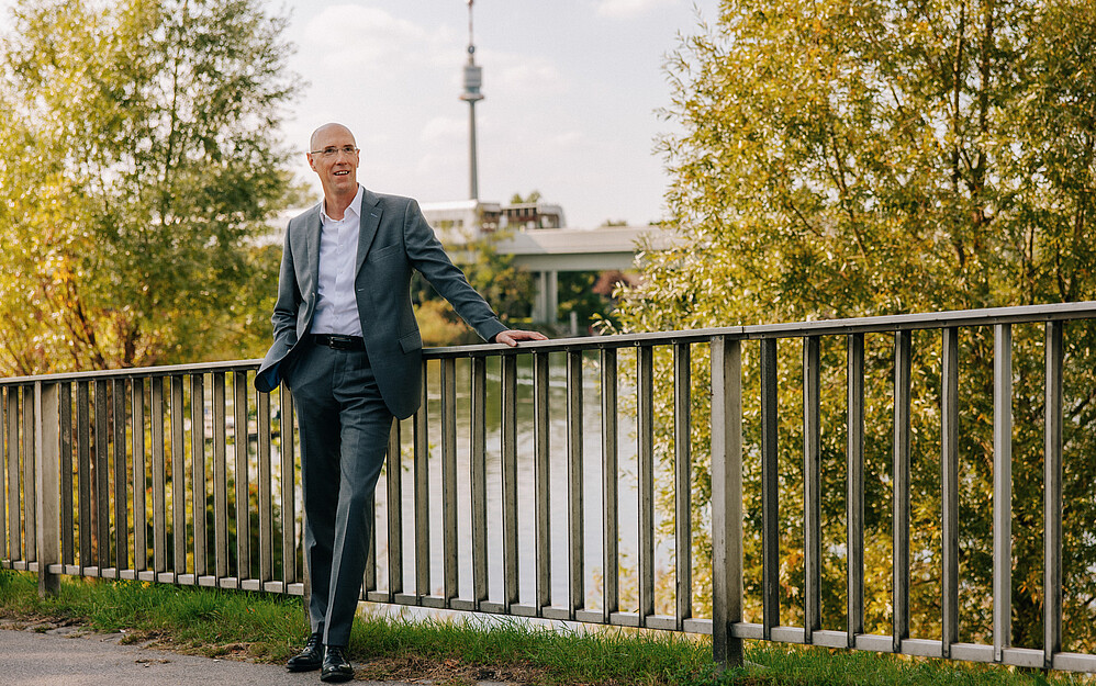 Man standing at a bridge railing at the Danube