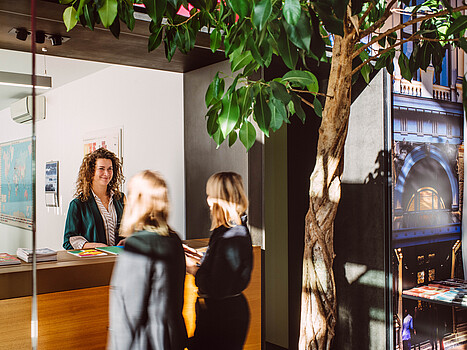 3 women talking to each other in a friendly consultation setting in an office building