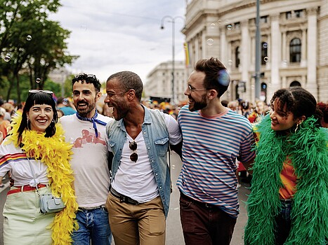 Group of smiling people standing in front of Vienna's Burgtheater