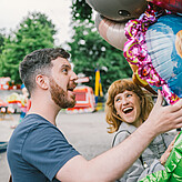 Man and woman with balloons smiling 