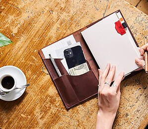 a paper republic leather notebook on a table with other accessories