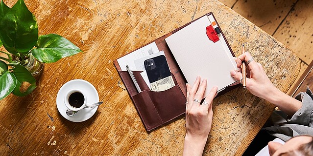 a paper republic leather notebook on a table with other accessories