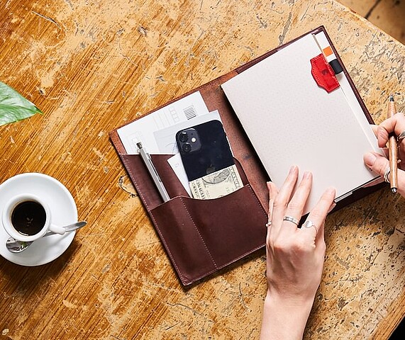 a paper republic leather notebook on a table with other accessories