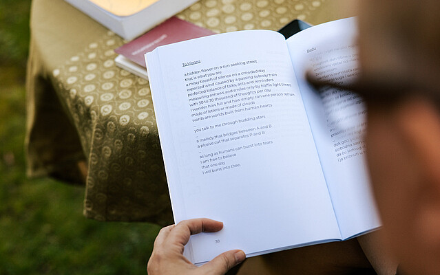 Person with glasses reading an open book