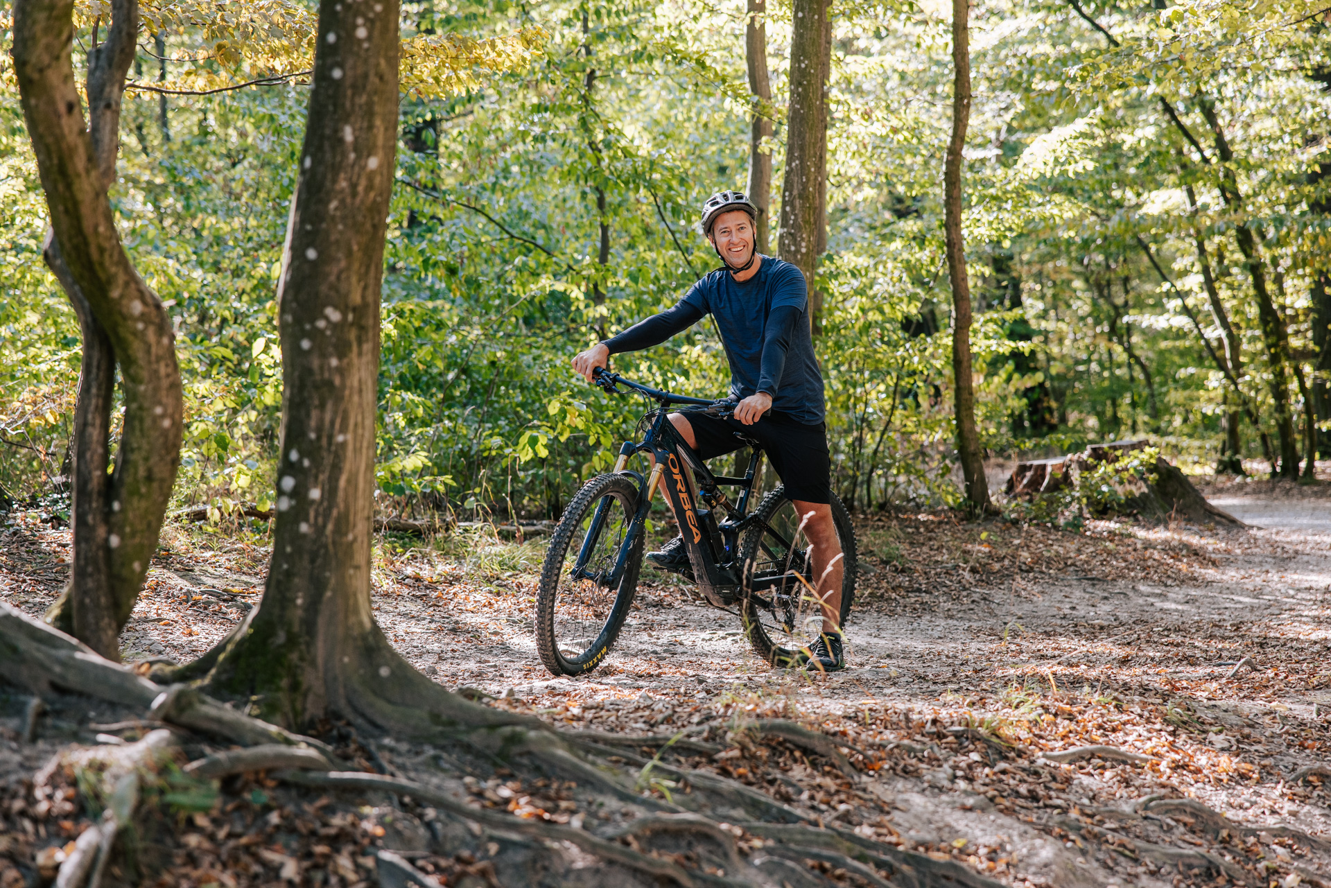 Male cyclist on his bike standing in the woods 