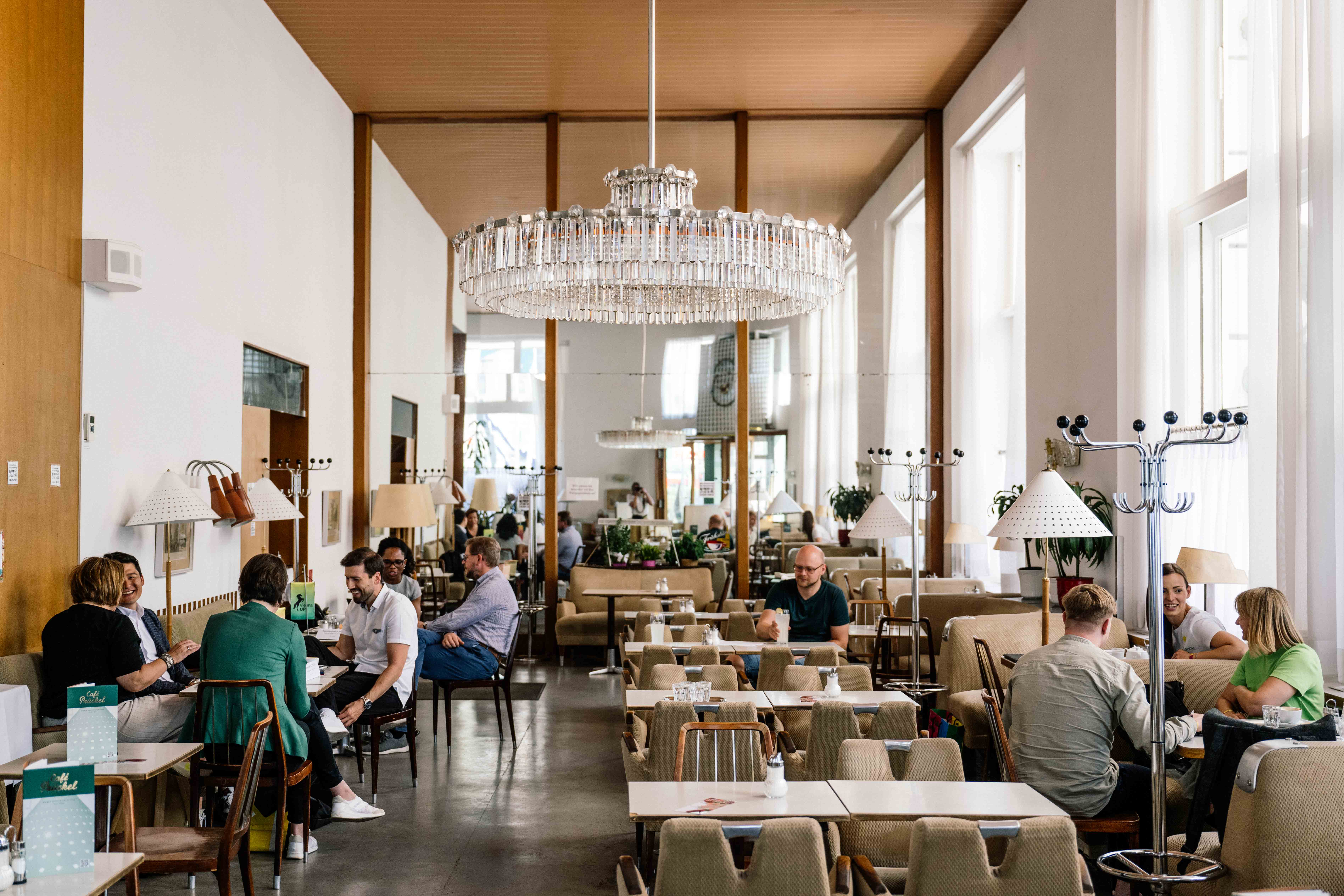 Light and airy modern hipster cafe with large chandelier in Vienna